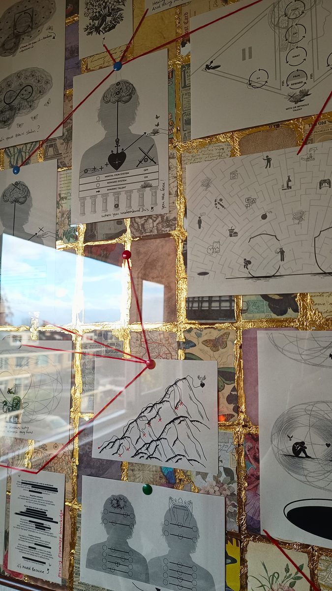 Detail van het werk: illustraties van hoofden, een berg en een doolhof, verbonden met rode draad over bladgoud.